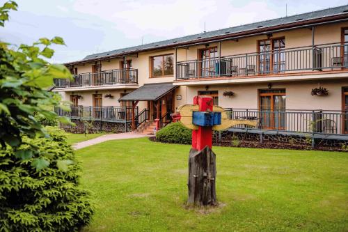 a post in the grass in front of a building at Sojka Resort in Bešeňová
