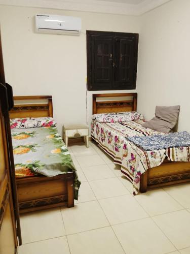 a bedroom with two beds and a cabinet in it at White Pearl Apartment in Alexandria