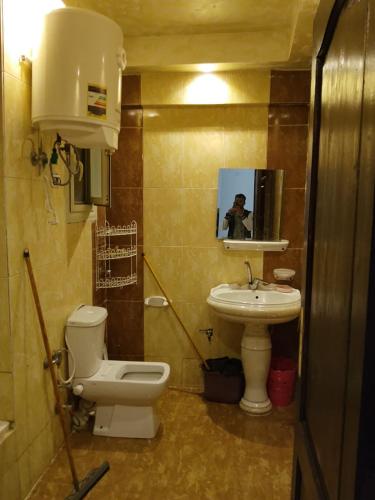 a bathroom with a toilet and a sink at White Pearl Apartment in Alexandria
