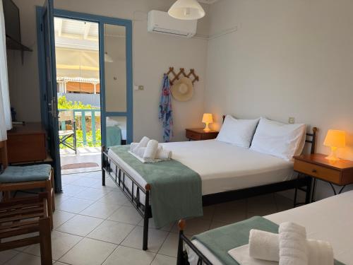 a bedroom with two beds and a balcony at Central Studios in Agios Nikitas pedestrian zone in Agios Nikitas