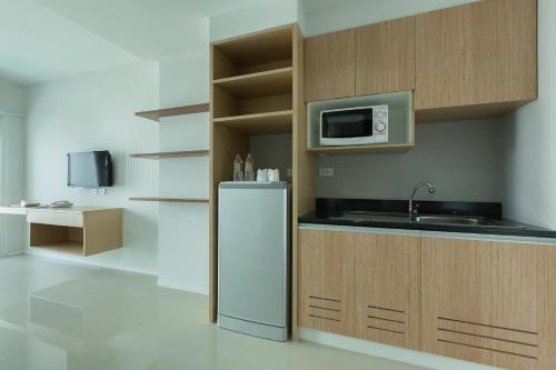 Thongchen Residence في Samut Sakhon: مطبخ مع ثلاجة وميكروويف
