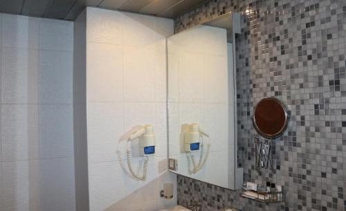 a shower in a bathroom with a mirror at Akkoç Butik Otel in Seyhan