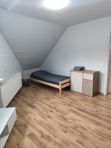 a room with a bed and a wooden floor at Centro-loftas in Telšiai