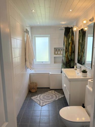 a bathroom with a tub and a toilet and a sink at Skid vm in Falun