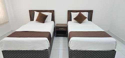 two beds sitting next to each other in a room at Today House Suites 5 in Salalah