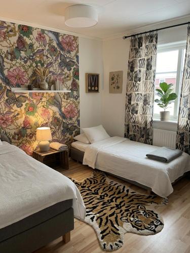 a bedroom with two beds and a rug at Skid vm in Falun
