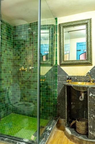 a bathroom with a shower and a sink and a mirror at Hotel Bin El Ouidane in Bine el Ouidane