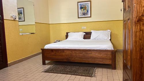 a bed with white sheets and pillows in a room at Royal hotel in Lomé