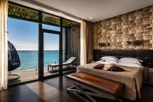 a bedroom with a bed and a view of the ocean at M1 Club Hotel in Odesa
