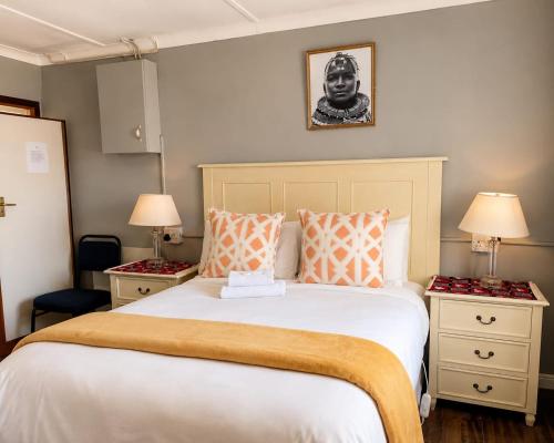 a bedroom with a large bed with orange and white pillows at Radies Bed and Breakfast in Cofimvaba