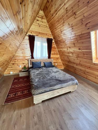 a bedroom with a bed in a wooden cabin at ValceleLakeRetreat in Merişani