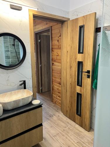 a bathroom with a sink and a wooden door at ValceleLakeRetreat in Merişani