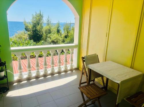 a table and a chair on a balcony with a window at Apartments Bacic in Prizba