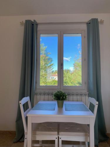 a white table and chairs in front of a window at Studio au 1er étage à la campagne in Callian