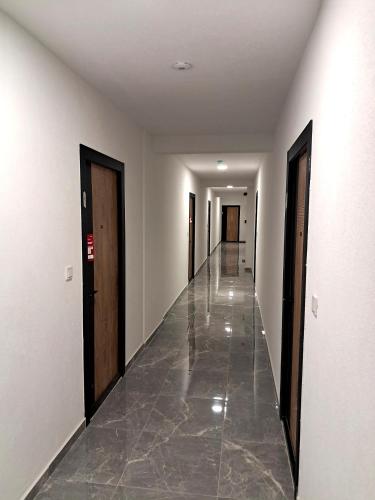 an empty hallway with doors and a tile floor at Apartpan Lekic in Bar