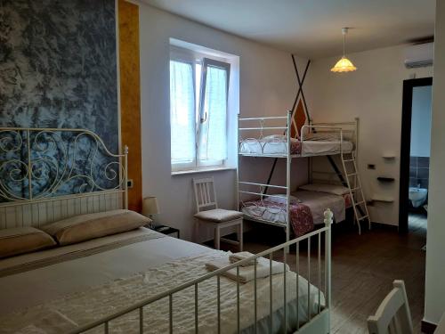 a bedroom with a bed and a bunk room with a window at La Dolce Dimora in Praia a Mare