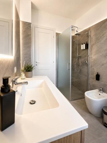 a white bathroom with a sink and a shower at Pierre Palace in Isola Sacra
