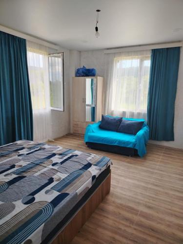 a bedroom with a bed and a couch in it at Ghulelebi - ღულელები in Ghulelebi