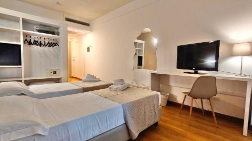 a hotel room with two beds and a flat screen tv at Hotel President in Prato