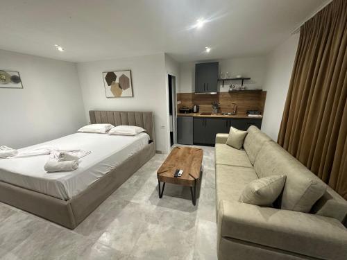 a hotel room with a bed and a couch at Lake Escape Villa Shirokë in Shkodër