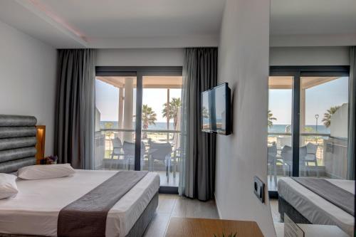 a hotel room with a bed and a balcony at Amalia Mare in Nea Vrasna