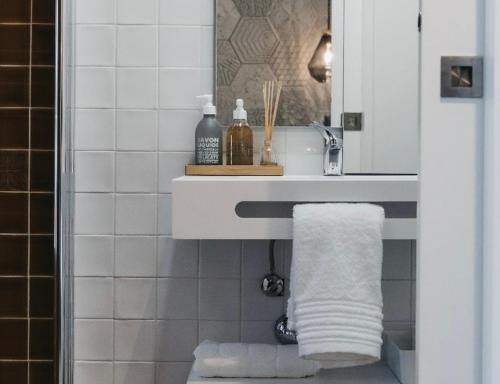 a bathroom with a sink and a towel at &Tales Suites - Óbidos in Óbidos