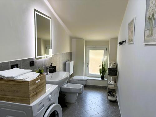 a white bathroom with a sink and a toilet at Station -Mansarda in posizione strategica, vista panoramica, letto king size e clima in Ivrea