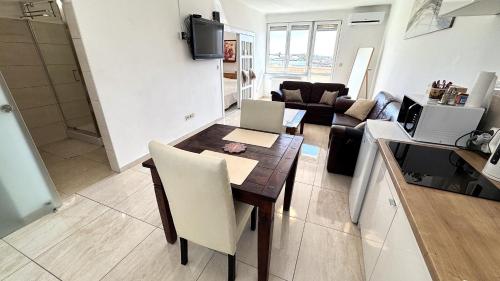 a kitchen and a living room with a table and chairs at Rest House Apartman in Nyíregyháza