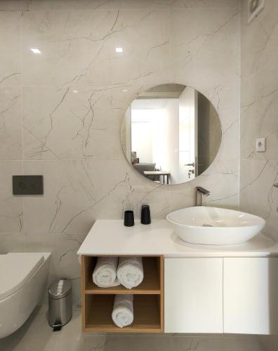 a white bathroom with a sink and a mirror at AlvaLoft Barreiro in Barreiro