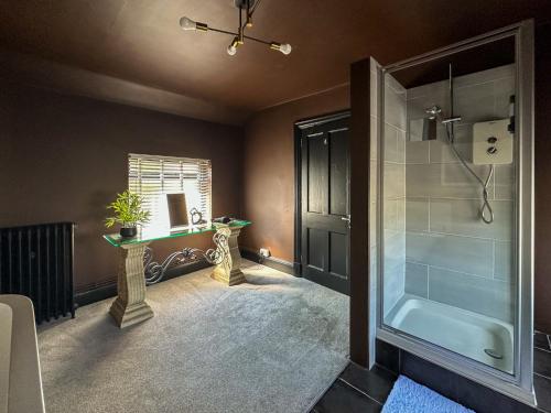 a bathroom with a shower and a sink and a tub at Cheshire Yeoman - Station Hotel in Hooton Station