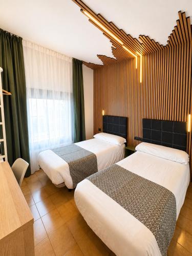 a hotel room with two beds and a window at Hotel Casado in Pas de la Casa