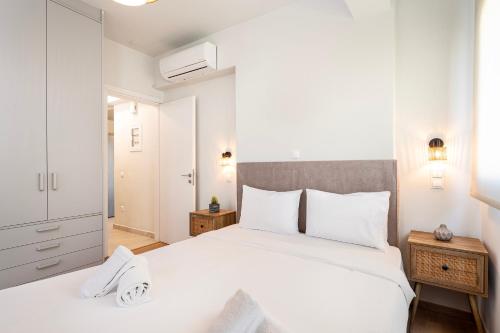 a bedroom with a large white bed with white pillows at Athenean Oasis in Ellinikon in Athens