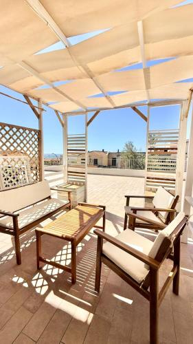 a patio with benches and tables on a roof at Il Soffione in Castelsardo
