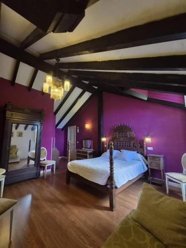 a bedroom with a bed and a purple wall at Posada torre del milano in Comillas