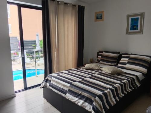 a bedroom with a bed with a view of a pool at IGGY in Malinska