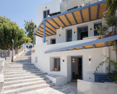 a white house with stairs leading up to it at Vivian Dio Choria Tinos in Dhió Kkhoriá
