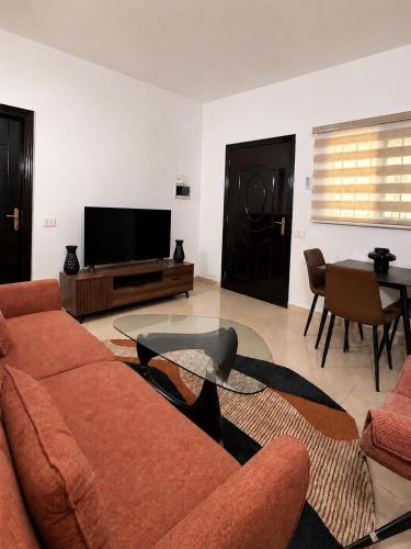 a living room with a couch and a tv at Étoile in Pointe-Noire