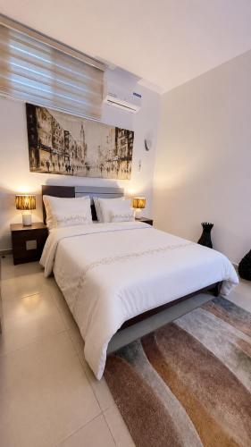 a large white bedroom with a large white bed at Étoile in Pointe-Noire