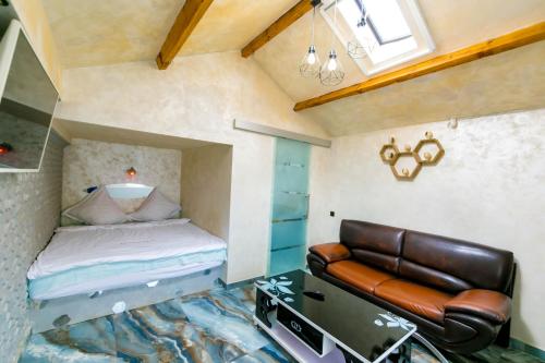 a small bedroom with a bed and a leather chair at Casa Yachi Vama Veche in Vama Veche