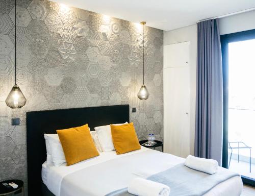 a bedroom with a large bed with yellow pillows at &Tales Suites - Óbidos in Óbidos