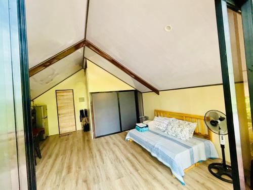 a large bedroom with a bed and a fan at Jeden Glass House Mountain View in Canayan