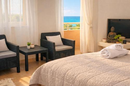 a bedroom with a bed and two chairs and a window at Durres Sun & Sea Luxury Apartment in Durrës