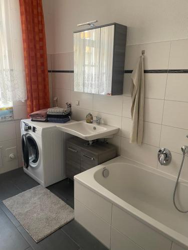 a bathroom with a sink and a washing machine at Ferienwohnung Jach in Triglitz