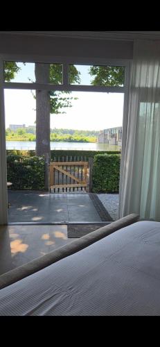 a bed in a bedroom with a view of a tree at B&B La Rivé in Maastricht