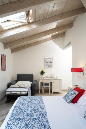 a bedroom with a bed and a couch and a table at La Ciliegina Lifestyle Hotel in Naples