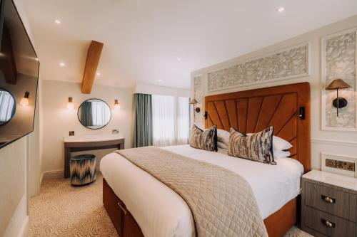 a bedroom with a large bed and a television at Skiddaw Hotel in Keswick