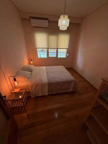 a bedroom with a large bed and a window at Το Σπίτι στον Πεζόδρομο in Grevena