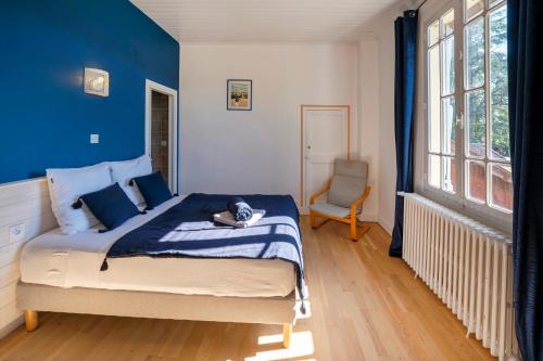 a bedroom with a bed with blue walls and a chair at La Pausa Verda in Montréal