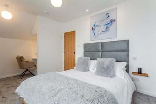 a bedroom with a large white bed and a chair at 2 Bed in Thurso oc-n41742 in Thurso