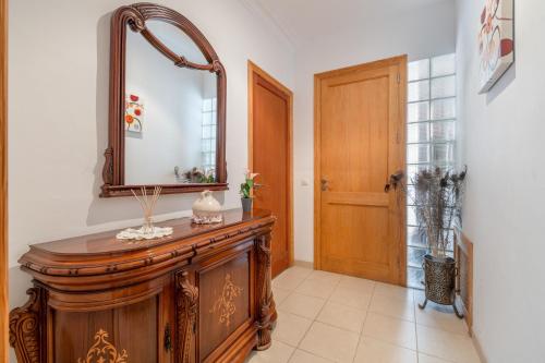 a mirror on top of a wooden dresser in a hallway at Casa Nord in El Port de la Selva